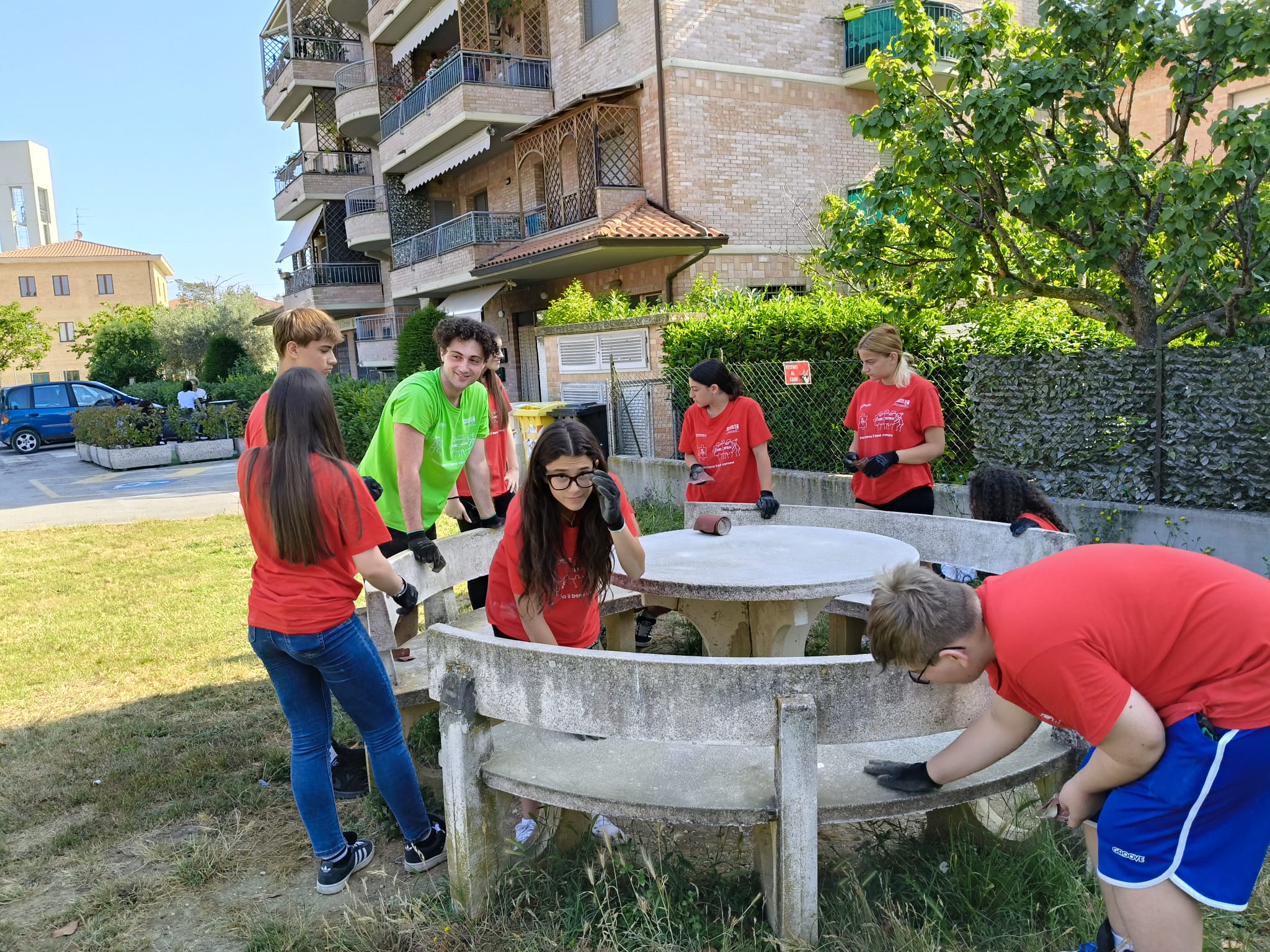 Foto di Alessandro Marchetti (maglia verde) con la prima squadra del progetto Ci sto affare fatica, mentre puliscono alcune panchine