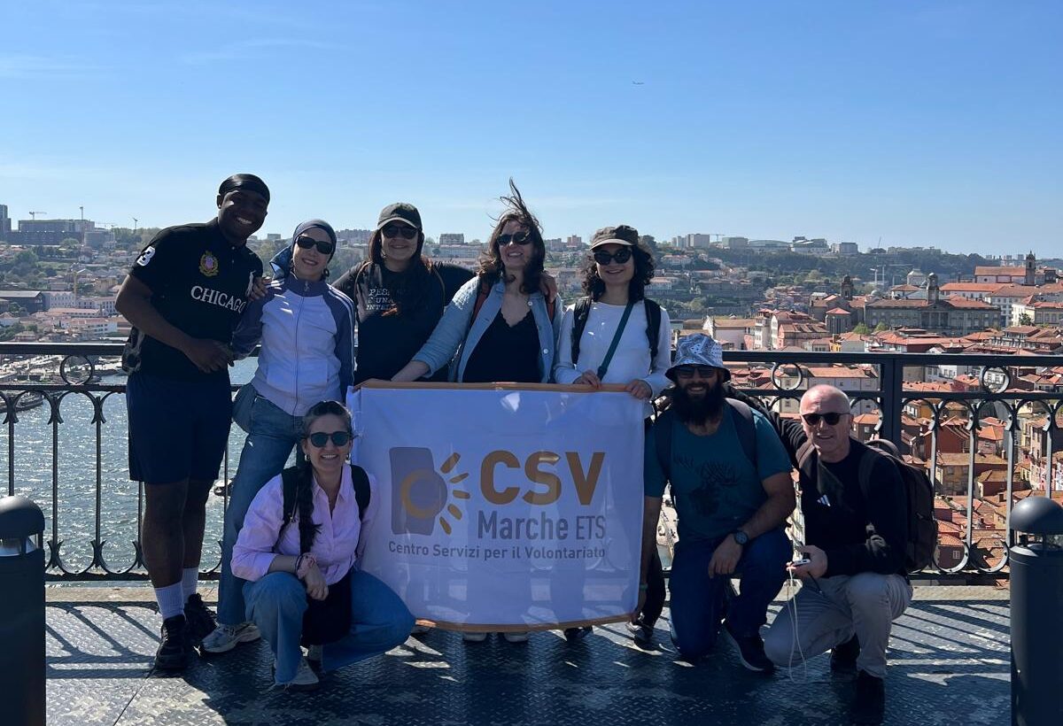 Un gruppo di persone in posa per foto, con bandiera del Csv Marche