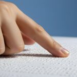 una mano che scorre un testo in braille