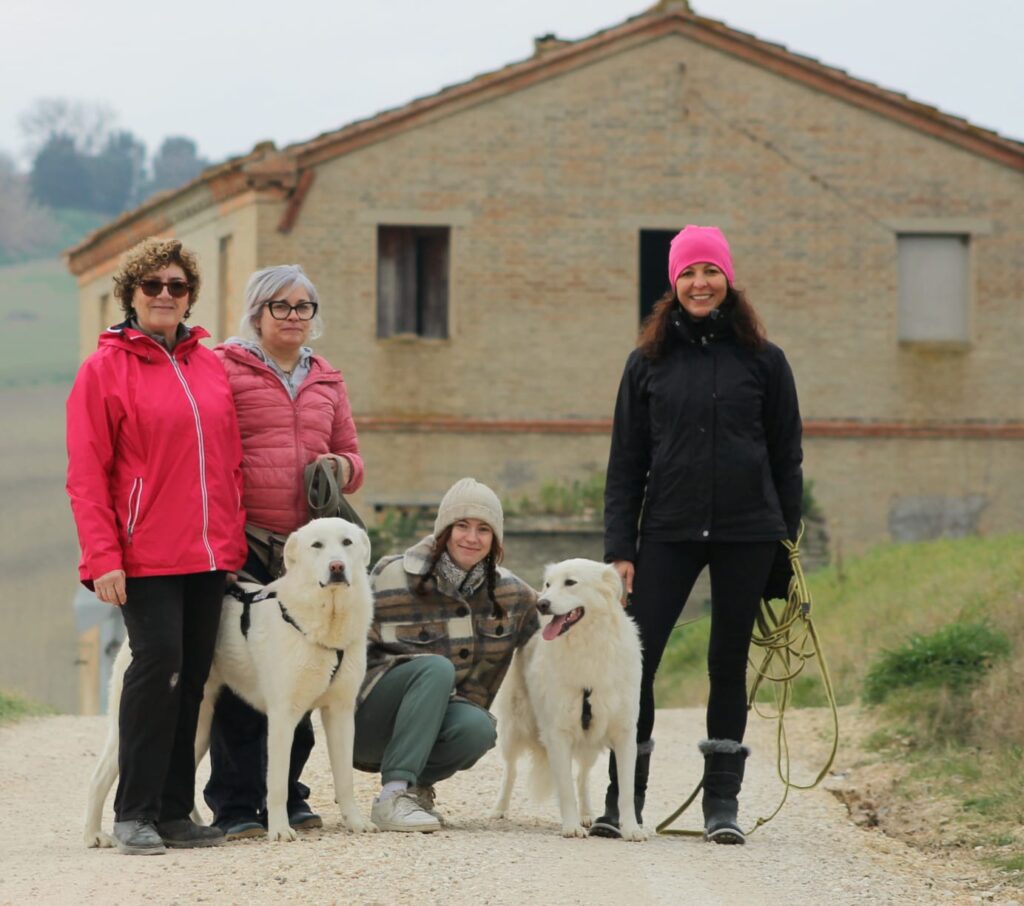 Foto di Noemi Saracini insieme ad altre tre volontarie e due cani bianchi