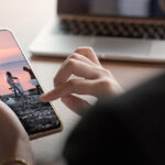 una persona guarda sullo smartphone una foto di volontari per l'ambiente