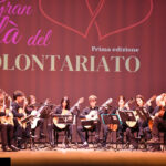 un ensemble di chitarre sul palco di un teatro