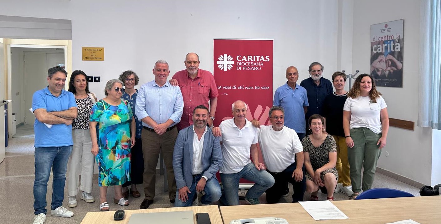 foto di gruppo dei relatori e dei rappresentanti delle associazioni, nella sede Caritas di Pesaro