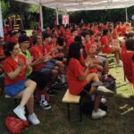 centinaia di ragazzi con la t shirt rossa del progetto applaudono durante l'evento finale