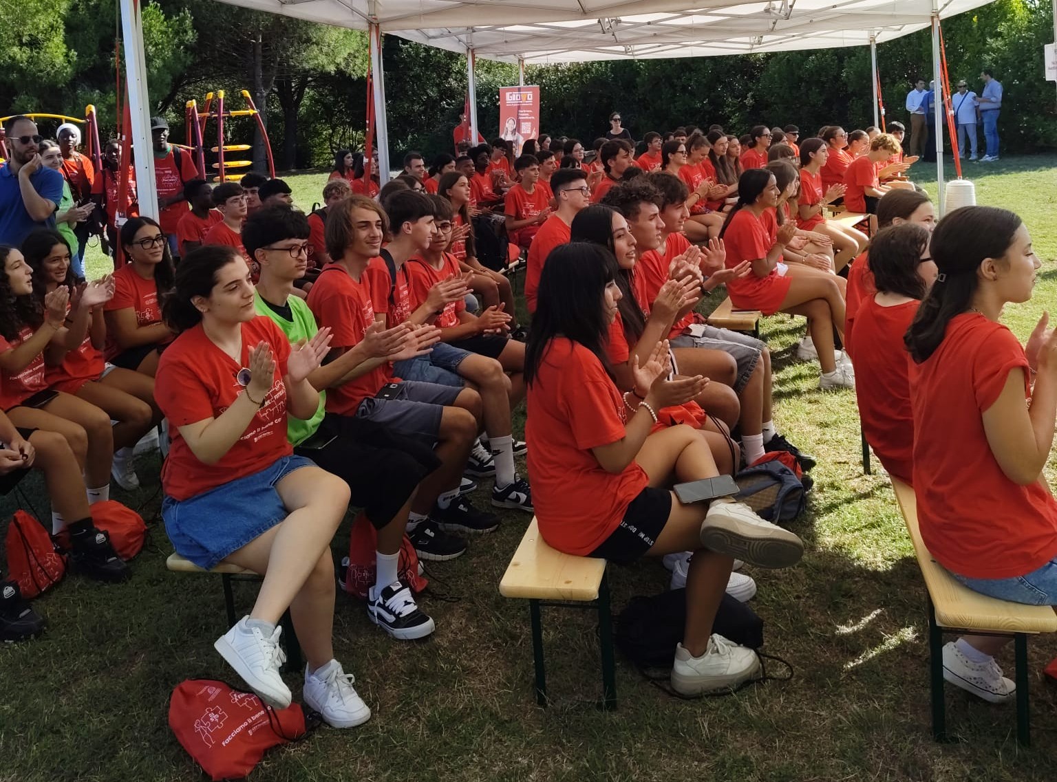 centinaia di ragazzi con la t shirt rossa del progetto applaudono durante l'evento finale