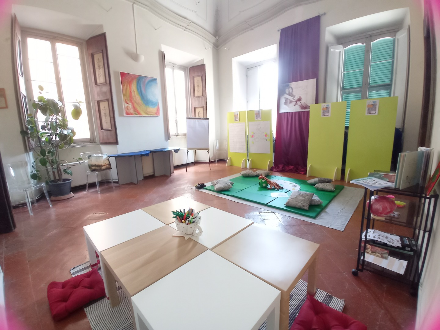 Una stanza arredata con tappetini e giochi per bambini