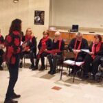 Una donna in una stanza e persone sedute intorno