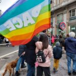alcuni manifestanti in corteo con una bandiera della pace
