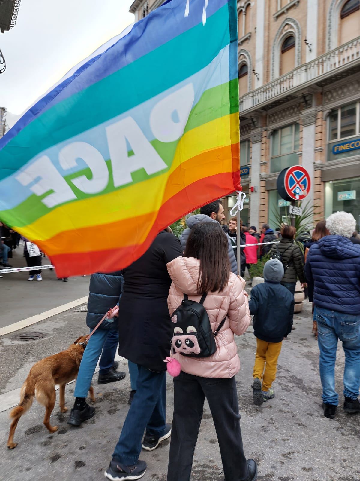 alcuni manifestanti in corteo con una bandiera della pace