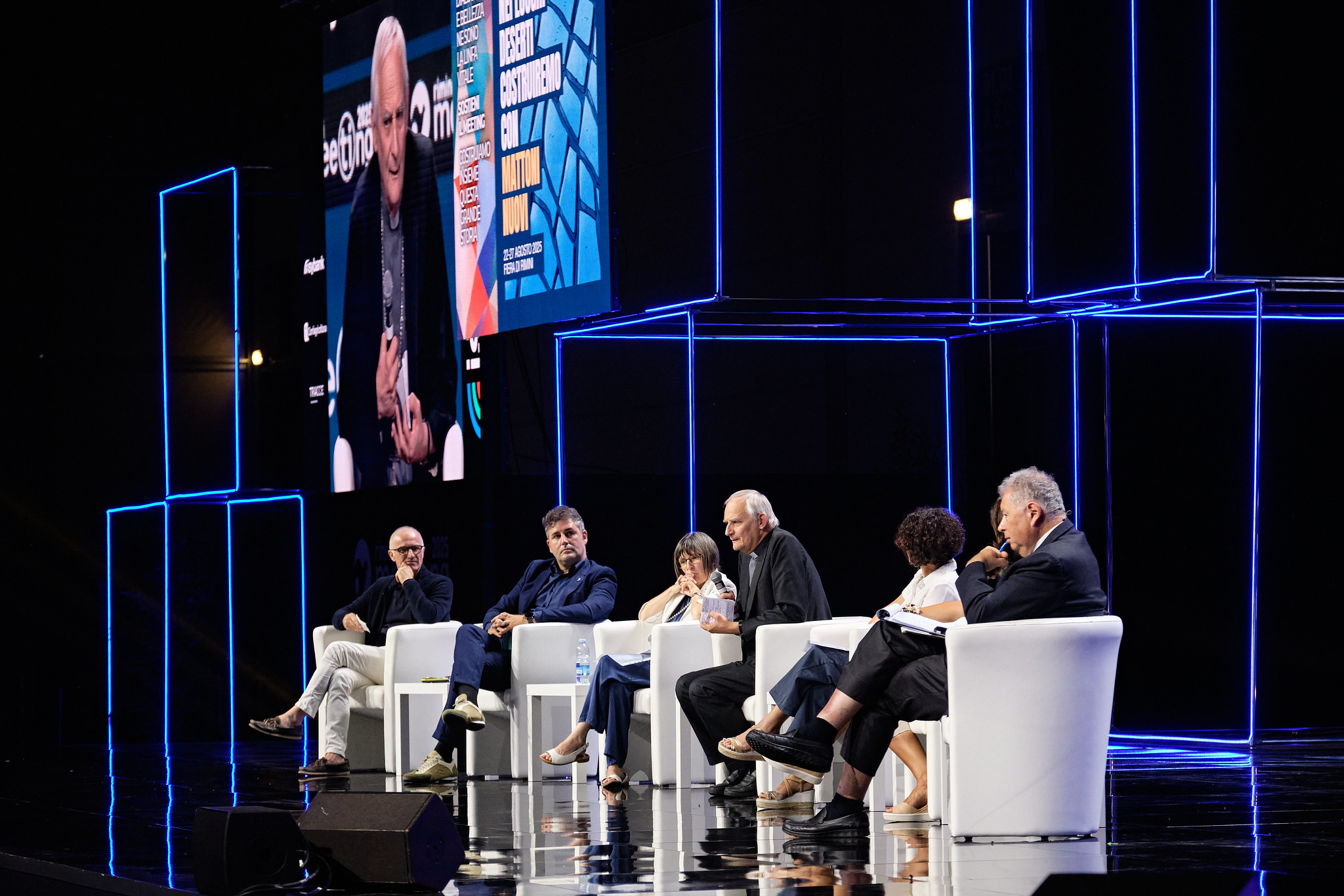 i relatori sul palco seduti su poltroncine