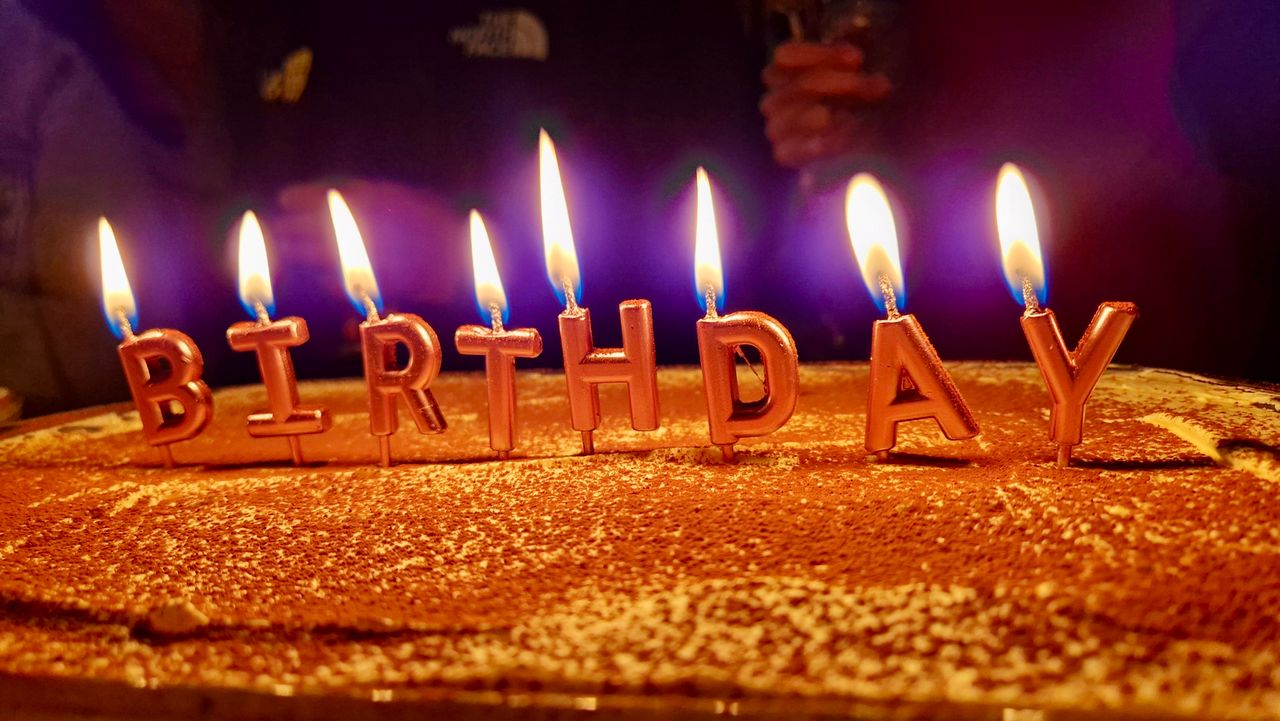 Una torta con delle candeline di buon compleanno