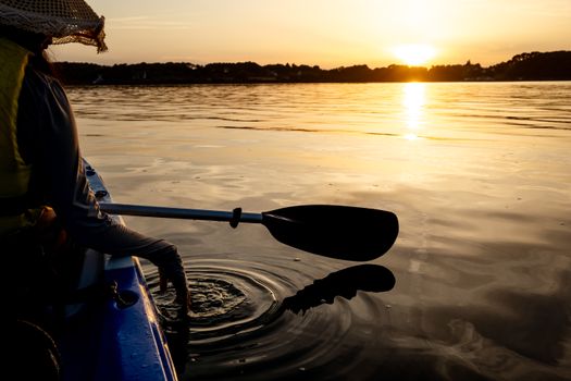 Il remo di un Kayak affona in acqua al tramonto