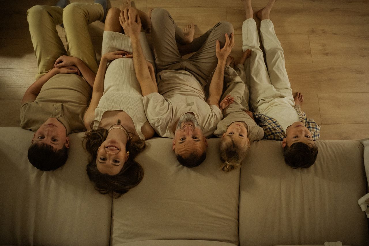 un gruppo di persone adulte e giovani seduto su un divano