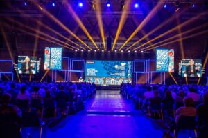 un auditorium gremito di pubblico e in fondo un palco con relatori