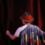 un attore dietro il sipario di un teatro