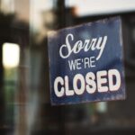 una porta con un cartello che riporta scritto "Sorry, we're closed"