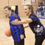 un'educatrice con un ragazzo disabile in un campo da basket